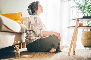 Foto op Canvas  Plus size woman doing yoga and meditation at home. © Mariia Korneeva