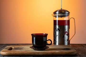 Glass flask with tea. Tea mug and teapot. Tea on the kitchen board.