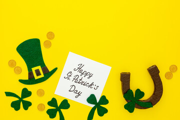 Composition for St. Patrick's Day. Decorating paper with green clover or shamrocks, leprechaun hat and horseshoe.