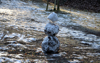 a snowman sadly slowly melting, dirty from mud and lack of snow will evoke a feeling of ruin and...