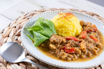 Keema curry and turmeric rice on a white plate