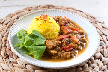 Keema curry and turmeric rice on a white plate