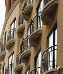 Fototapeta premium Building Facade With Tall Windows And Wrought Iron Railing Balconies