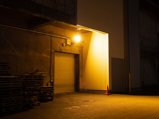 夜の倉庫の入り口のライトの明かり