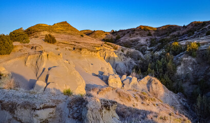 Fototapeta na wymiar Geological stony-clay landscape, mountains and rocks in the evening at sunset. North Dakota