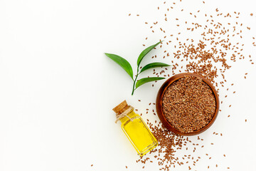 Flax seeds in a spoon and bowl with a bottle of flaxseed oil - obrazy, fototapety, plakaty