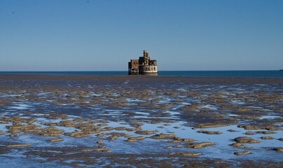Grain battery tower during low tide with blue sky in the background, Kent, UK