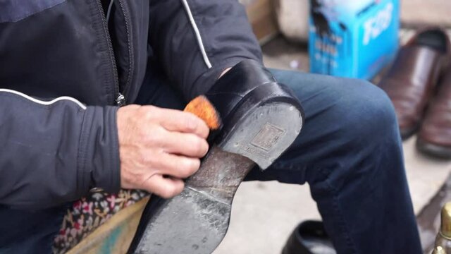 shoe painter master. leather shoe painting and repair. street counter, dealer. they Polish leather shoes with their hands