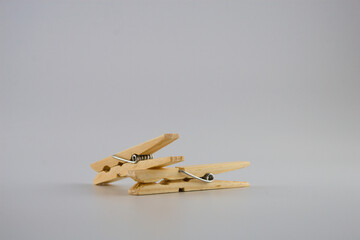 Two natural wooden pegs on the top of each other isolated on a white background, close-up