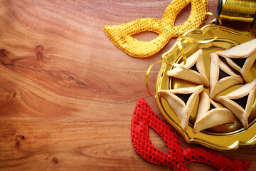 Purim celebration concept (jewish carnival holiday) over wooden background. Top view, flat lay