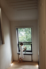 lovely bride in a wedding robe is going to the wedding. a hoop on the bride's head. the bride is going home. happy girl. bridal bouquet of peonies