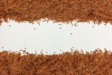 brown Flax seeds scattered on a white table