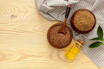 Flaxseeds in a spoon and bowl with a bottle of flaxseed oil and flaxseed flour