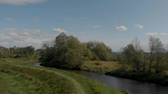 Drone 4K Footage Cloverdale of a dike levee trail in the rural backdrop with scenic terrain and revealing a highway in the distance