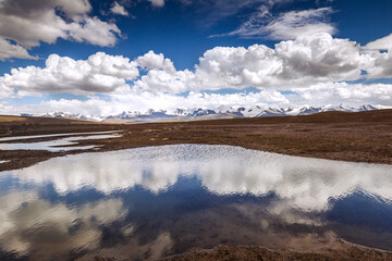 Mountains and clouds reflecting in the water; Kyrgyzstan