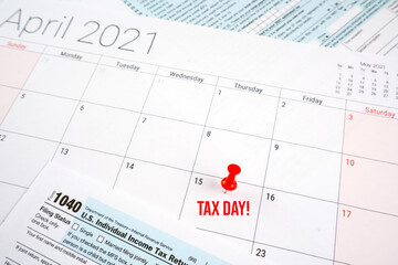 us individual income tax return 1040 form for 2020 with tax day text and red pin on april 15th on april 2021 calendar.