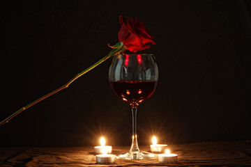 red rose, red wine, and candles on the table