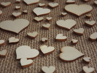 wooden hearts of different sizes on jute fabric as a Valentine's day greeting card. High quality photo