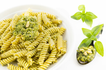 Pasta al pesto, foglie di basilico con sfondo bianco