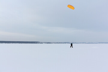 Man training with a kite on a frozen river in  winter, Kama Reservoir, Perm city, Russia