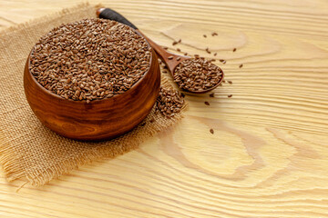 Flax seeds in a spoon and bowl with a bottle of flaxseed oil