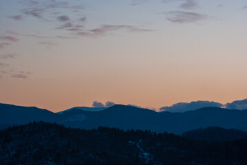 Silhouette of hills and forest at sunset