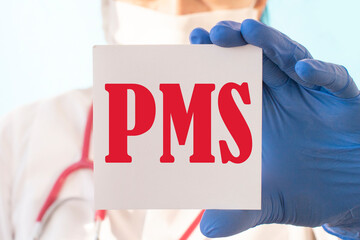 Female doctor in blue latex gloves holding a tablet with the text: PMS