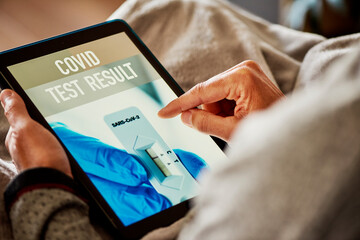 checking the result of his covid test in his tablet