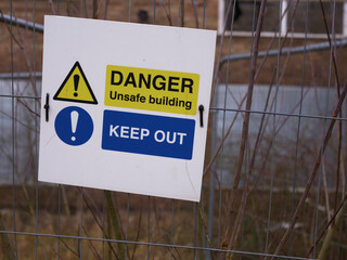 Danger sign outside derelict urban building after fire