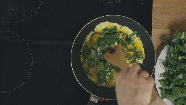 Chef making an omellet with spinach