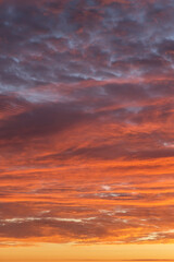 Obraz premium Epic Dramatic sunrise, sunset orange red yellow pink clouds against blue sky background texture