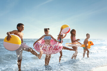Cute children enjoying sunny day at beach. Summer camp