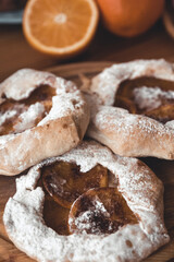 Fresh cookies with fruit orange jelly and mint on plate over rustic wooden background