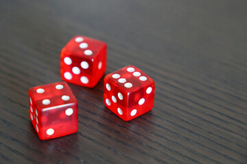 Red dice on dark wooden table. Background for casino games, gambling, luck or randomness