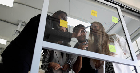 Business team group meeting with sticky post on mirror glass board to brainstorming and sharing new...