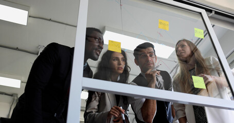 Business team group meeting with sticky post on mirror glass board to brainstorming and sharing new...
