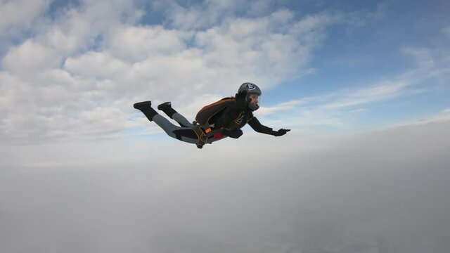 Skydiving. A pretty girl is flying in the cold sky.