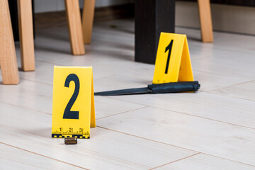 A shell casing or bullet at a crime scene with evidence markers.
