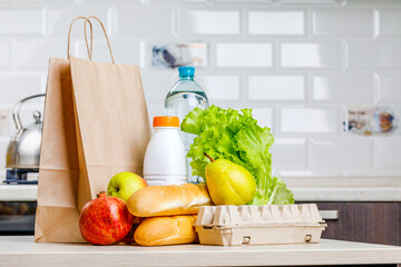 Secure home delivery. A box with various products such as milk, fruit and bread in the kitchen