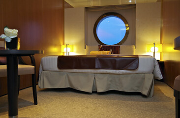 Oceanview or outside cabin stateroom with large porthole window on modern luxury cruiseship or...