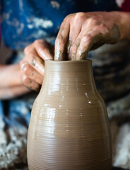 Potter hands making in clay on pottery wheel. Potter makes on the pottery wheel