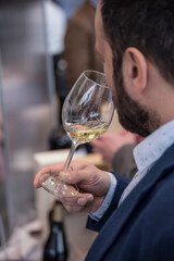 Closeup of man smelling wine before drinking it. Drinking wine in luxury restaurant. Tasting a glass of wine.
