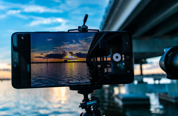 Sunset over the river through a phone