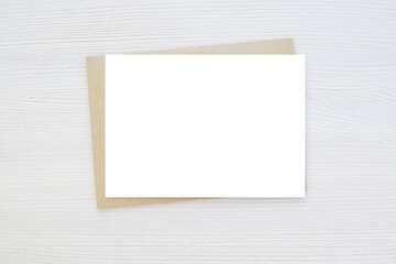 Blank horizontal card mockup, invitation, greeting card mock up, brown envelope, wooden background, minimal style.