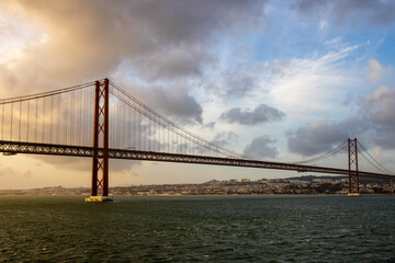 Fototapeta na wymiar The 25 April bridge (Ponte 25 de Abril) - famous bridge in Lisbon and among of the longest ones in Europe. 