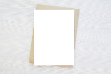 Blank vertical card mockup, invitation, greeting card mock up, brown envelope, wooden background,...