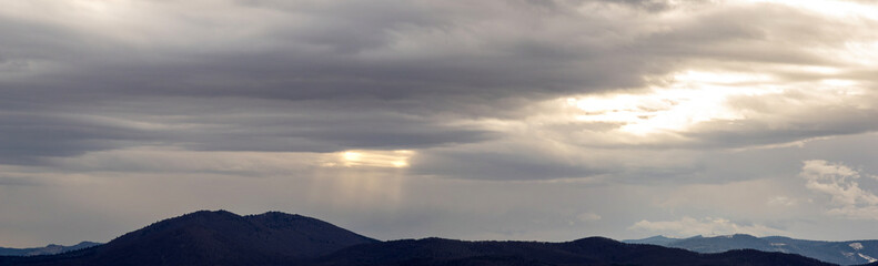 Fototapeta premium Clouds at sunset in winter in the mountains