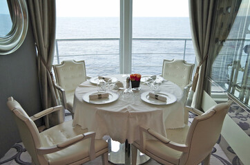 Elegant formal dining room or restaurant onboard luxury cruiseship or cruise ship liner in white...