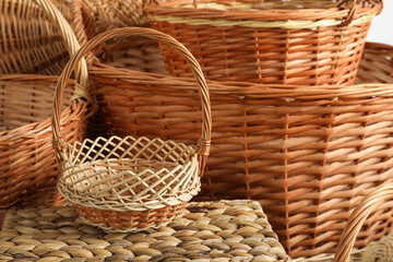 Many different wicker baskets made of natural material as background, closeup