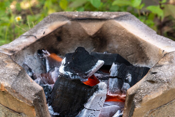 Burning black charcoal in the old stove with paper and dry wood. It produces a lot of smoke when it burns.